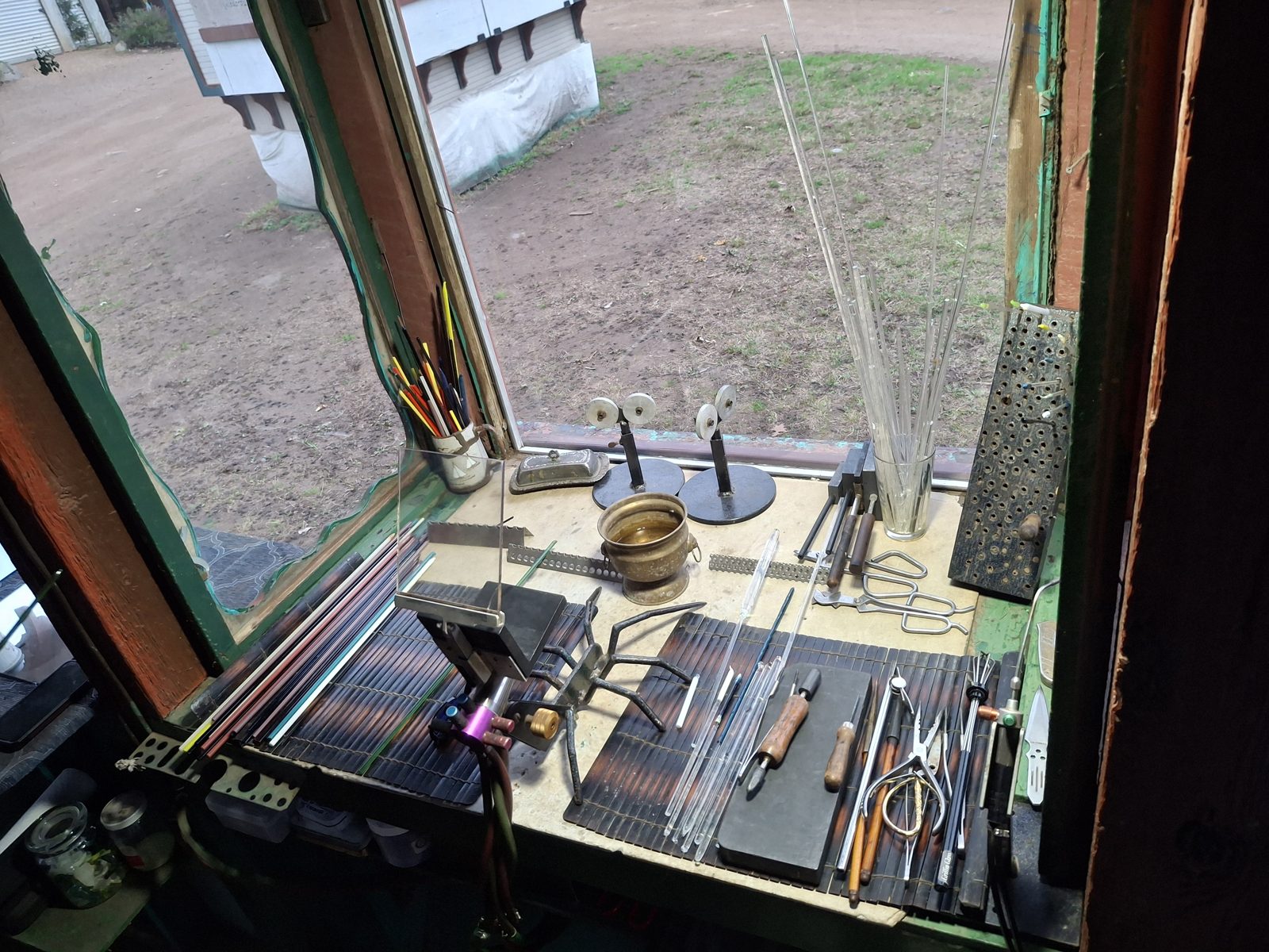 Lampworking bench with glass rods, tools, and torch